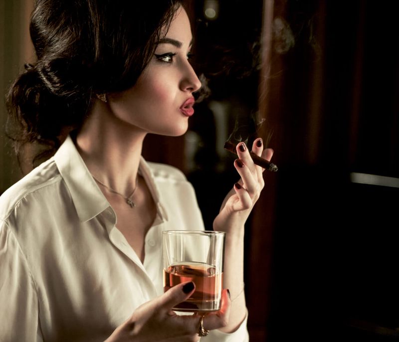 Femme qui boit du rhum et fume un cigare